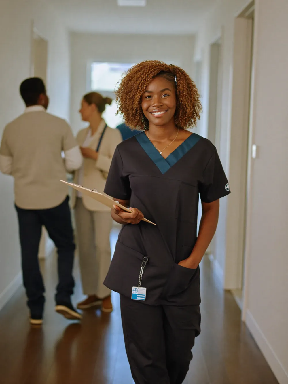 A care professional with a clipboard in a bright care-home hallway